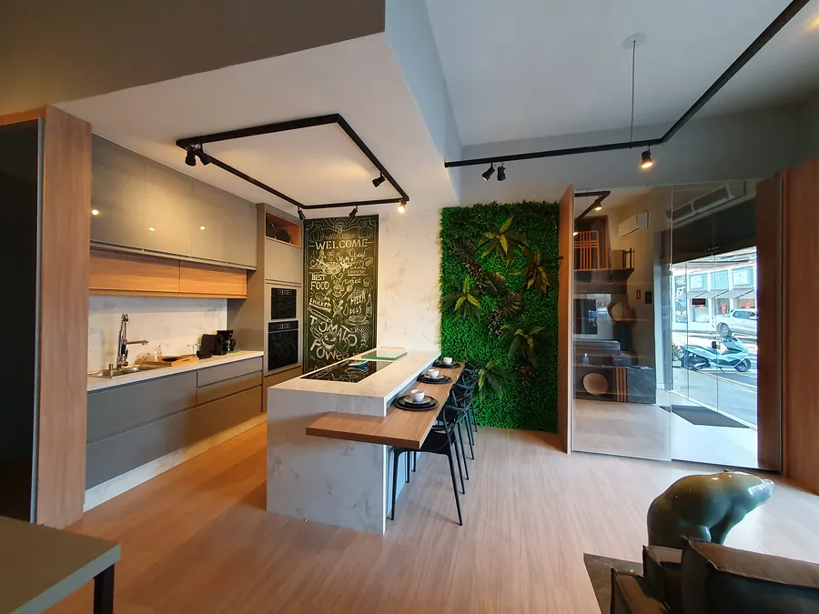 Cozinha do showroom vista de lado, com painel ripado em madeira